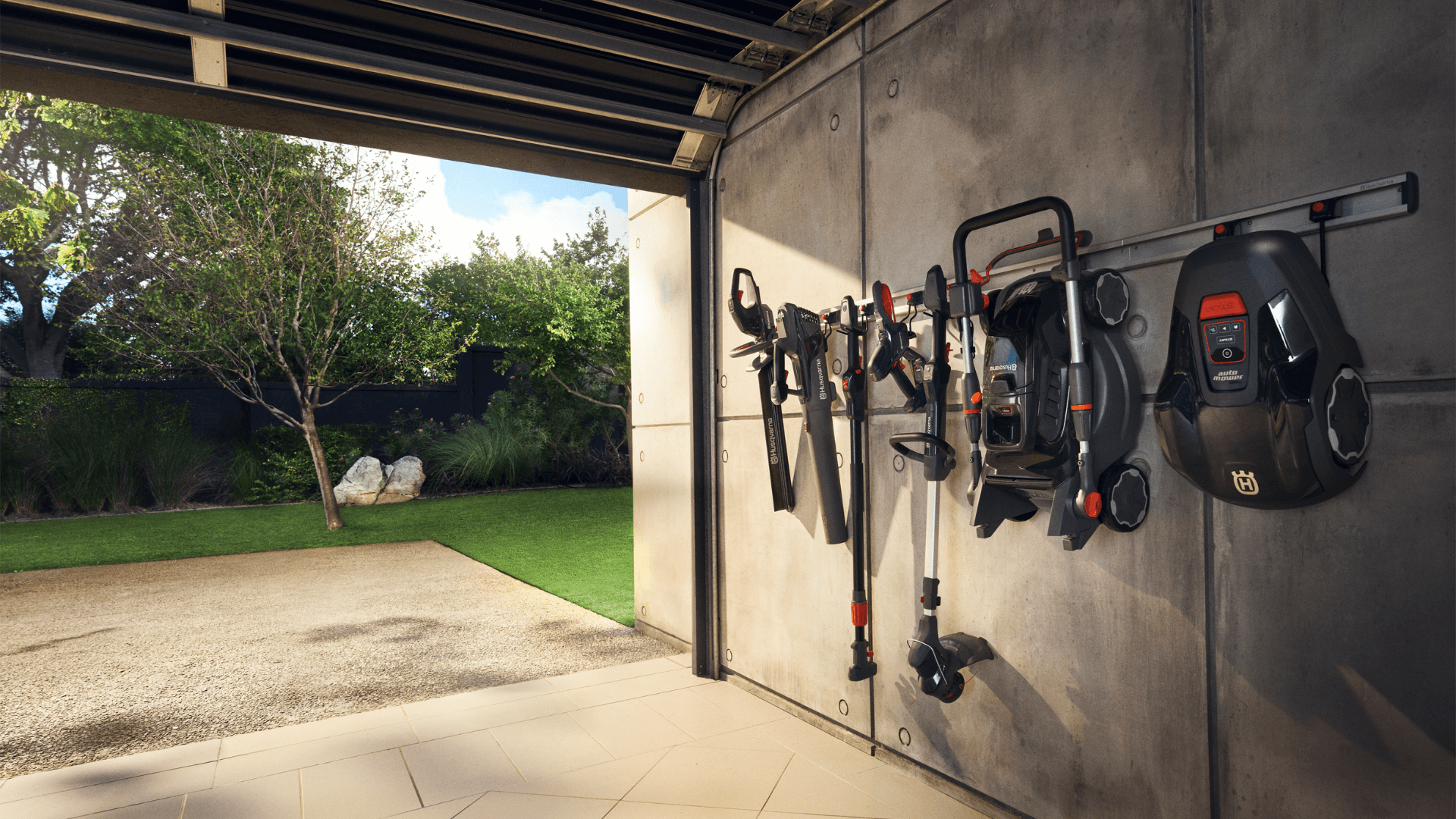 range of Husqvarna Aspire products hung on garage wall overlooking green garden